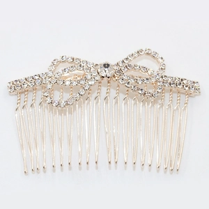 Golden hair comb with sparkling rhinestones in a delicate bow shape for hair styling