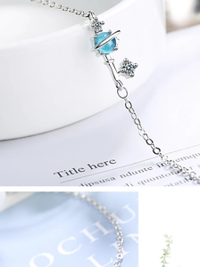 Macro shot of blue planet charm and silver chain with sparkling zircon star details