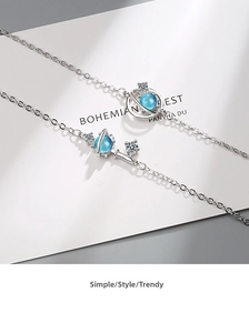 Detailed close-up of blue planet charm and silver planet key bracelet with zircon stones