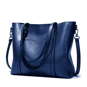 Détail du grand cabas en cuir grainé bleu marine avec poignées et boucles métalliques