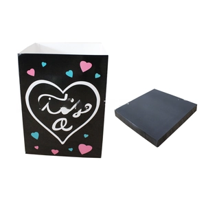 Détail de la boîte cadeau noire Gender Reveal avec motif cœur et texte it's a