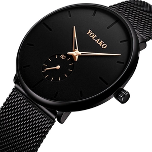 Detailed macro view of black mesh strap watch with gold accents and YOLAKO dial