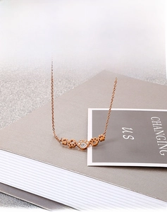 Détail du collier pendentif patte de chat en or rose avec strass blancs brillants