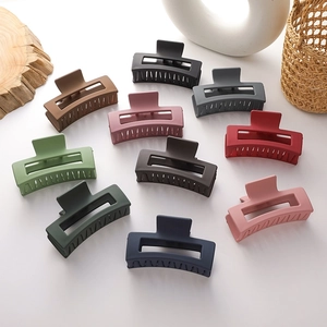 Matte finish large square hair claws in ten colors arranged on minimalist background