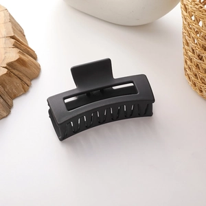 Detail of matte black hollow rectangular hair claw clip for elegant hair styling