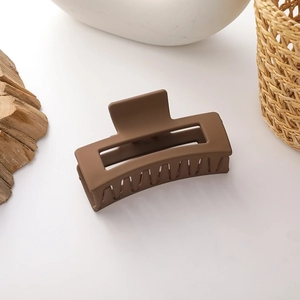 Detail view of large matte brown rectangular hair claw clip with multi-tooth structure