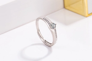 Macro shot of silver zircon ring showing classic round cut center stone and side diamonds