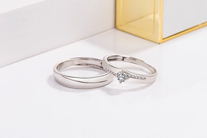 Elegant silver couple rings set with cubic zirconia stones on a minimalist white display
