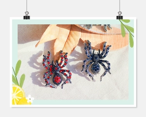 Detailed close-up of retro spider brooches with sparkling crystals in red and blue colors