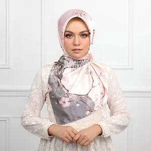 Detailed texture of pink floral satin scarf with carriage chain print and contrast hem