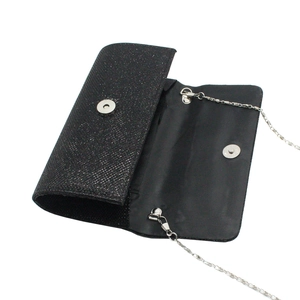 Detail of black glitter evening clutch with silver chain strap and magnetic closure