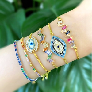 Gold evil eye bracelet set with colorful cubic zirconia on woman's wrist