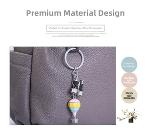 Close-up of hot air balloon keychain with binoculars pendant on leather bag