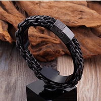 Close-up of black braided leather men's bracelet with a sleek metallic magnetic clasp