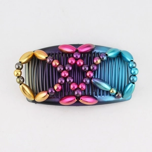 Detail of magic hair comb featuring blue-purple gradient beads and golden cross patterns