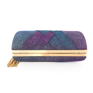 Dettaglio della borsa da sera sfumata blu-viola con trama glitterata e nappina dorata