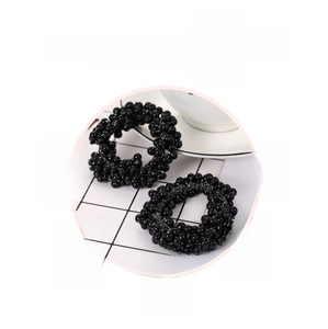 Gros plan sur des chouchous perlés noirs flexibles avec une texture élastique