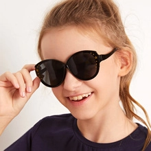 Close-up of child wearing black sunglasses with golden star accents on frames