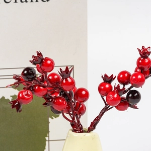 Artificial red pomegranate berry branches in a ceramic vase for Christmas decoration