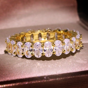 Macro shot of luxury gold eternity ring with sparkling oval cut cubic zirconia stones