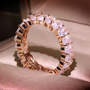 Macro detail of rose gold ring with full band of oval cut sparkling cubic zirconia