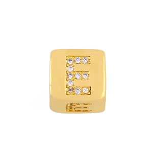 Detailed macro view of golden square letter E charm with sparkling cubic zirconia inlay