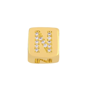 Macro view of gold square letter N charm with sparkling white zircon inlay for DIY jewelry