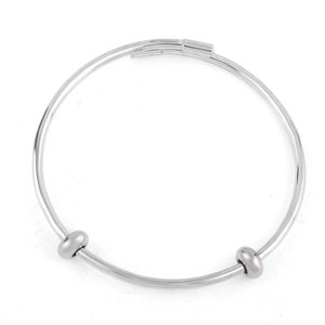 Close-up of adjustable silver bangle featuring two sliding beads and smooth metal texture