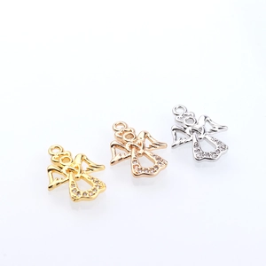 Trois pendentifs anges en or et argent avec cristaux de zircone sur un fond clair