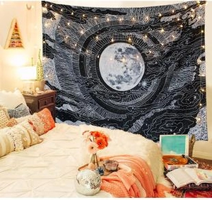 Detailed view of black and white celestial tapestry with stars and moon on bedroom wall