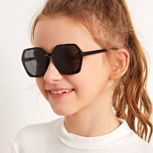Detail of child wearing retro hexagonal black sunglasses with silver rivet accents