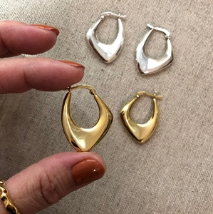 Detail of minimalist 925 sterling silver drop earrings with polished gold and silver finish