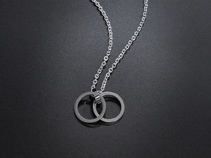 Detailed close-up of interlocking silver rings on a sleek black textured background
