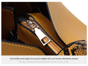 Macro view of silver zipper detail and snake pattern leather on yellow handbag