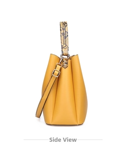 Side view of yellow leather bucket bag with snakeskin pattern handle and metal rivets