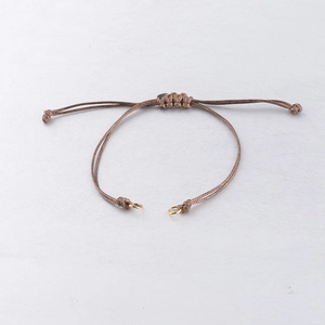Detail of adjustable brown wax cord bracelet with golden metal rings for DIY jewelry
