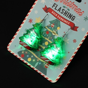 Flashing green Christmas tree earrings with glowing LED lights on festive display card