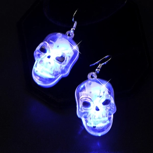 Macro shot of skull-shaped earrings with glowing blue LED lights on dark background