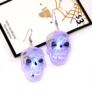 Halloween LED light-up skull earrings in transparent purple with glowing blue effect