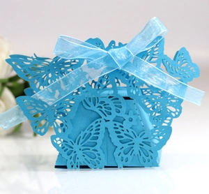 Macro shot of sky blue laser-cut butterfly candy box with matching organza ribbon