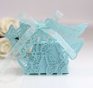 Macro detail of laser-cut butterfly candy box with light blue ribbon and paper texture