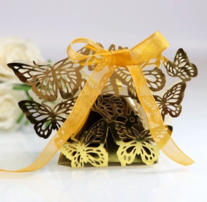 Laser-cut gold butterfly candy box with a warm yellow ribbon for wedding favors