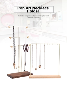 Detail of gold metal necklace stands with wooden bases in minimalist Nordic style