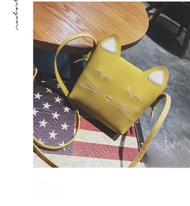 Close-up of cat-shaped crossbody bag with embroidered cat face and cute ears