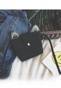 Detailed view of kids cute cat-ear crossbody bag in black felt with metal snap button