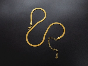 Close-up of a 18K gold plated herringbone chain with adjustable tail and lobster clasp