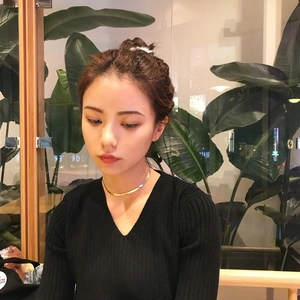 Detailed view of an 18K gold-plated flat snake chain choker worn with a black V-neck top