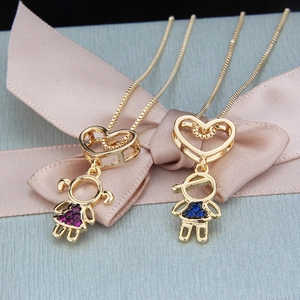 Detailed shot of heart-shaped boy and girl necklaces with pink and blue zircons