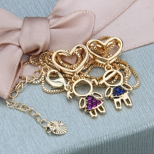 Macro view of gold-plated boy and girl heart pendants with purple and blue cubic zirconia