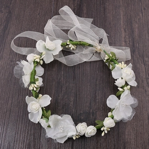 Detail of white fabric rose flower headband with berries and a sheer ribbon bow